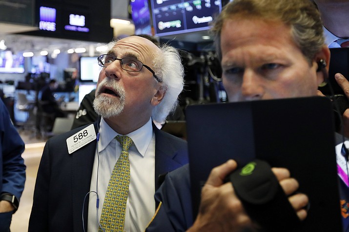 trader peter tuchman, left, works on the floor of the new york