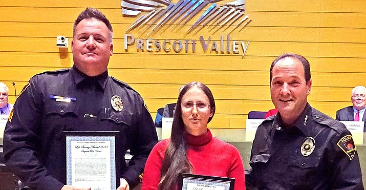 Sgt. Rob Brown, left, and civilian Micaela Adams, center, receive the Lifesaving Award from Prescott Valley Police Chief Bryan Jarrell at the Dec. 20 Town Council meeting. (PVPD/Courtesy)