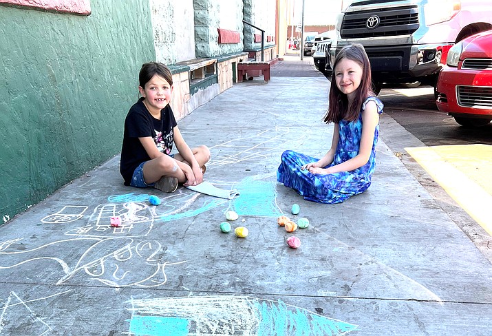 Khalees Peasley and Baylie Diaz create some sidewalk art with chalk June 15 in Williams. (Wendy Howell/WGCN)