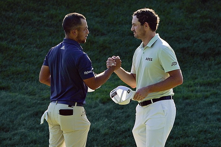 Xander Schauffele, left, and Patrick Cantlay shake hands after finishing the third round of the Travelers Championship golf tournament at TPC River Highlands, Saturday, June 25, 2022, in Cromwell, Conn. Schauffele finished one stroke ahead of Cantley for the lead heading into the final round on Sunday. (Seth Wenig/AP)