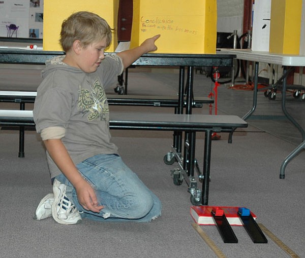 BB/CCN Photo/LeeAnn Lyall<br>
Fourth-grade student at Black Canyon City’s Canon Elementary School, Chris Kennedy demonstrates to the audience that the weight of an object does not determine the speed of its descent toward earth with his weighted car experiment. The science fair took place on May 22.
