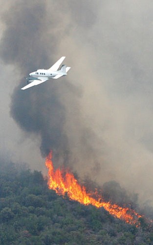 A lead plane flies over the Lane 2 fire near Crown King last week. Firefighters have 95 percent containment on the blaze and the Crown King area will be open to the public again on Wednesday.