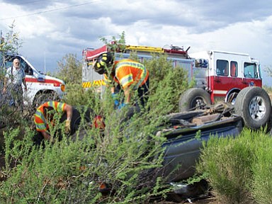 Mayer firefighters Steve Valdez and Captain/Paramedic Tom Haney work at the scene of a rollover accident about a mile in from Highway 69 on Monday, May 18.<br>
Photo courtesy Mayer Fire