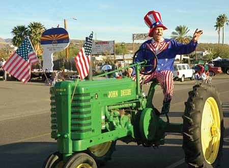 Richard Borg of Tractors of the Past RV Park in Black Canyon City waves to the crowd during the community's Veteran's Day Parade on Saturday. Hundreds of people lined the roads to enjoy the parade and other activities during the day's Fun Fest event.<br>
BBNPhoto/Cheryl Hartz