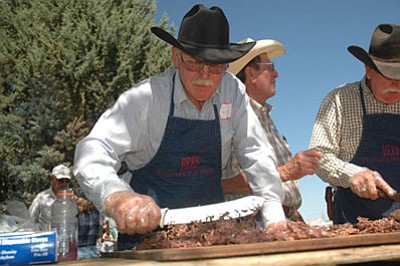 Alan Kessler cuts beef at a Yavapai Cattle Growers annual barbecue. The Kesslers have long involved themselves in ranching education and public service.<br>
File Photo/Heidi Dahms Foster