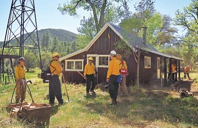 Matt Hinshaw/The Daily Courier<br>
Firefighters from Prescott and Camp Verde take a break after clearing defensible space around a home in the community of Pine Flat Thursday afternoon.