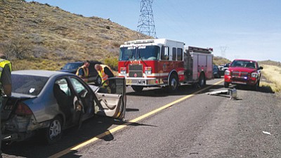 Courtesy photo<br>
Firefighter Jonathon Graham and captain/paramedic Tom Haney examine a vehicle that spun out on I-17 near Cordes Junction Friday.