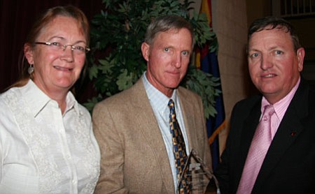 Arizona Farm Bureau President Kevin Rogers (far right) congratulates Don and Anne Verner for winning the Environmental Stewardship Award.
