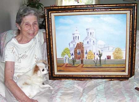 Lois Toy, with her little dog, Macho, shows her painting of the San Xavier Mission near Tucson.