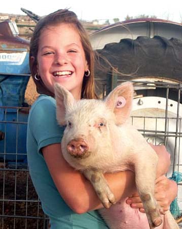Courtesy photo/Michelle Stevens
Chino Valley Breakaway Latigos 4-H Club member Janie Stevens holds a pig that may be in the club's Educational Petting Zoo Saturday near the arena on the Yavapai College's Chino Valley campus during First Territorial Capital Days.