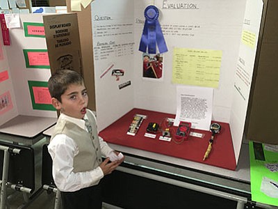 Mingus Springs Charter School student Brody Allen explains his blue ribbon-winning science project at the school’s science fair on Thursday, Nov. 12. Allen conducted battery tests to see which would last the longest. (Ken Sain/Review)