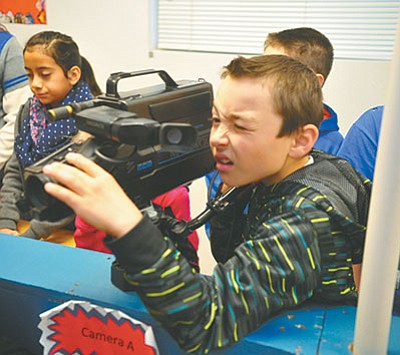 Fourth grader Keegan Quinn works the camera during the morning announcements on KDRN at Del Rio Elementary School in Chino Valley Thursday morning. (Les Stukenberg/PNI)