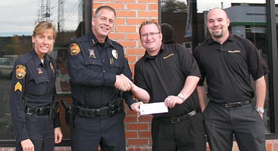 Prescott Police Department/Courtesy<br>Prescott Police Sgt. Georgia Davies, far left, and Chief Mike Kabbel, left, accept a check for the Youth Role Model Scholarship Fund from Matt Anderson, right, and Aaron Meisheid, far right, co-owners of the Firehouse Kitchen Restaurant.