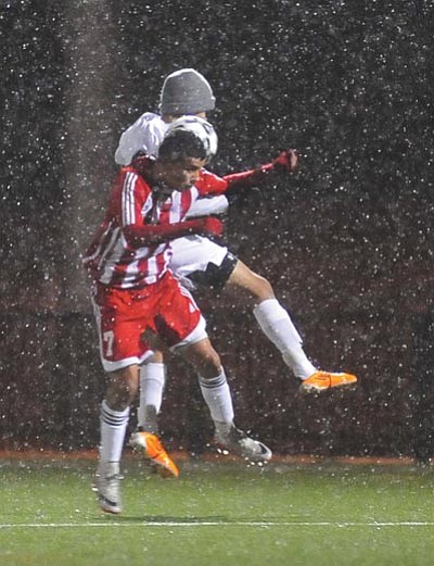 Photos by Les Stukenberg/The Daily Courier<br /><br /><!-- 1upcrlf2 -->In the blowing snow, Bradshaw’s German Ayala (above) goes for a header on the ball against Camelback Thursday night at Mountain Valley Park in Prescott Valley. Bradshaw’s Kenneth Castro (below) attempts a slide tackle.