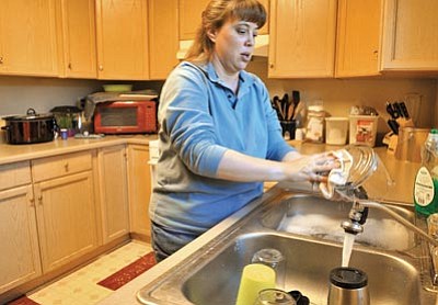 Matt Hinshaw/The Daily Courier<br>Virginia Midkiff does some household chores Friday afternoon at her home in Prescott Valley. Midkiff has been renting her home since 2009, but the property was recently foreclosed on.
