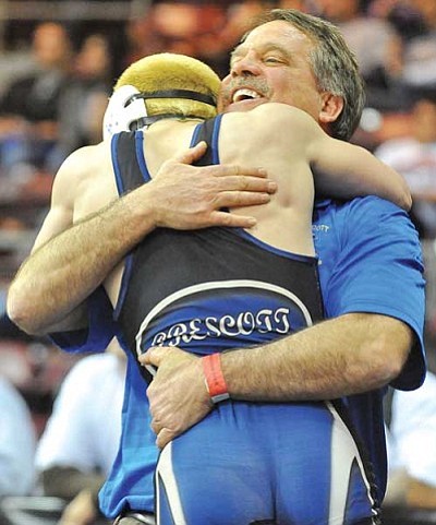 Matt Hinshaw/The Daily Courier<br /><br /><!-- 1upcrlf2 -->Prescott High 120-pound wrestler Mike Burkeen receives a big hug from coach Eric Koehler after taking third place Saturday afternoon during the Division II High School State Wrestling Championship tournament at Tim’s Toyota Center in Prescott Valley.