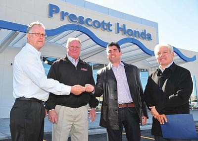 Les Stukenberg/The Daily Courier<br>Former Prescott Honda owners, at left, Don Biele and Gary Young pass the key to the new owners Chris and Bob Zamora Thursday at the dealership’s new location at 3291 Willow Creek Road in Prescott.