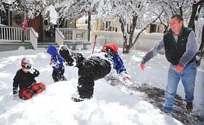 Les Stukenberg/The Daily Courier<br>Travis Newby tosses next door neighbor Cash Scarpignato into a snow bank on March 19 after an early spring storm dumped up to 12 inches of snow around the tri-city area.