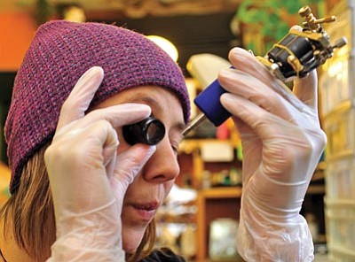 Matt Hinshaw/The Daily Courier<br>
Eva Rupert, an apprentice tattoo artist at Port Hole to Soul Tattoo and Piercing, checks the needle on a tattoo machine Saturday afternoon on Gurley Street in Prescott.
