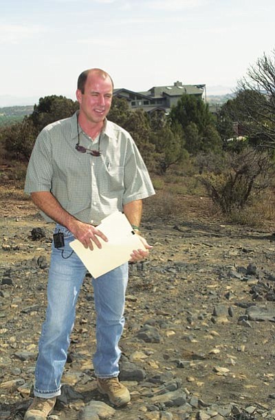 Les Stukenberg/The Daily Courier<br>
Richard Collison stands on some of the 
7 acres of defensible space he had cleared at his Cathedral Pines home prior to the 2002 Indian Fire. The space he cleared was credited by forest service officials as a significant factor in stopping the fire.