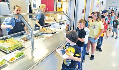 Matt Hinshaw/The Daily Courier<br>Patty Carreras and Debra Cunningham serve lunch to kids during the free summer lunch program at Taylor Hicks Elementary in Prescott Thursday afternoon.