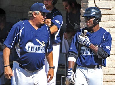 Matt Hinshaw/The Daily Courier<br>
Montezuma Federals Manager Pete LaCock talks with left fielder Steven Wright before his at bat Friday afternoon against the Sonoran Explorers at Roughrider Park in Prescott.