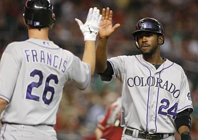 Rick Scuteri/AP Photo<br>
Colorado’s Dexter Fowler, right, celebrates with Jeff Francis in the third inning after both of them scored on a double by Marco Scutaro Wednesday in Phoenix.