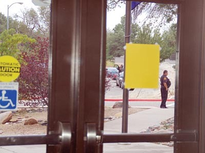 Lisa Irish/The Daily Courier<br>
Prescott Police Officer Ed Siller stands guard outside Abia Judd Elementary School with other officers during a lockdown Tuesday afternoon at school and nearby Granite Mountain Middle School after two teachers reported hearing three shots fired.