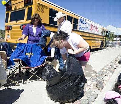 Les Stukenberg/The Daily Courier<br>
Director of Transportation Norma Frye, left, driver Craig Aper and volunteer Shalina George gather coats during the Prescott Unified School District’s Transportation Department Stuff the Bus event at the Prescott Wal-Mart on Highway 69 Saturday. As of about noon they had already received donations of over 150 coats for needy adults and children.