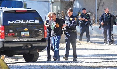 Matt Hinshaw/The Daily Courier<br>
Members of the Prescott Police Department escort a suspect who was involved in a stand-off to a waiting police vehicle at the Thunderbird mobile home park on White Spar Road Wednesday afternoon in Prescott.