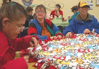 Lisa Irish/The Daily Courier<br>
Rayma, left, and Rena, center, who asked that their last names not be used, and Keith Mason, right, with the Special Needs Activity Program, make baby blankets for the Crisis Pregnancy Center during their craft night Thursday, Nov. 15 at the Adult Center in Prescott.