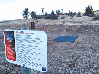 Courtesy photo<br>At left, a sign provides information about the disc golf course.
