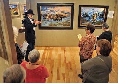 Matt Hinshaw/The Daily Courier<br>Artist Dave Powell, right, talks with docents, volunteers, and guests about his oil paintings "Yellow Boy & Robes" and "Ware Party Coming" during a preview of the Phippen Museum's Early West Storyteller Exhibit Friday March 1 in Prescott.  The exhibit runs through July 7 at the Marley Gallery inside the Phippen Museum.