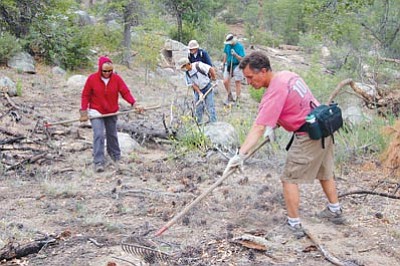 Joanna Dodder/Courier<br> Prescott Mountain Bike Alliance members help re-vegetate and hide an illegal trail on the Prescott National Forest a few years ago near Thumb Butte.