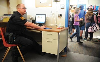 Les Stukenberg/The Daily Courier<br>
Prescott police officers like Peter Tomasovitch, above, can now use an office at Washington Traditional School to remotely file and view reports during their shifts. The pilot program will also give officers a higher visibility in and around the school.
