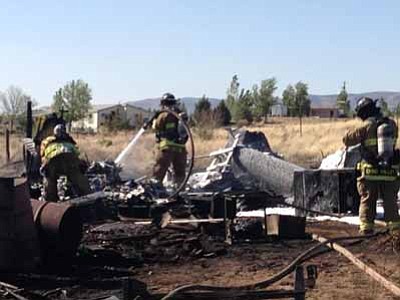 Courtesy Chino Valley Fire District<br>
A wildland fire burned several outbuildings in Paulden on Sunday afternoon after the wind lifted sparks from a burn barrel, igniting grass and weeds.
