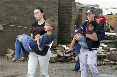 Teachers carry children away from Briarwood Elementary school after a tornado destroyed the school in south Oklahoma City, Okla, Monday, May 20, 2013. Near SW 149th and Hudson. (AP Photo/ The Oklahoman, Paul Hellstern)