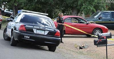 Prescott Valley Police stand outside the home on Truwood Drive where an adult male was shot by his son on Friday, June 7. Les Stukenberg/The Daily Courier