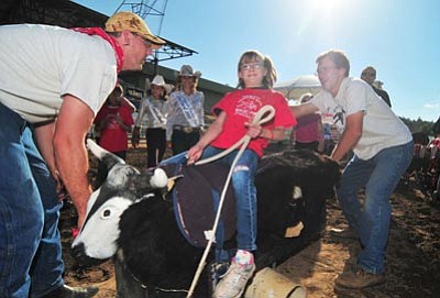 Les Stukenberg/The Daily Courier<br>Sabrina Sautter, 11 of Prescott Valley, gets in a bull ride during the 2012 Happy Hearts Rodeo for Exception Children before the opening performance of the Prescott Frontier Days Rodeo in Prescott.