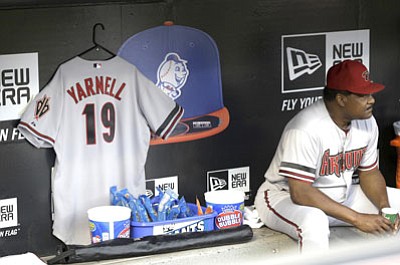 Seth Wenig/The Associated Press<br>A jersey honoring the 19 firefighters that were killed in the wildfire in Yarnell hangs in the Diamondbacks dugout Monday night at Citi Field in New York.