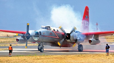 Matt Hinshaw/The Daily Courier<br>
A slurry bomber helping the attack on the Yarnell Hill fire reloads at the Prescott Municipal Airport.