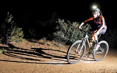 Matt Hinshaw/The Daily Courier<br>Armed with a helmet light, Taylor Liden competes in the 12 Hours at Night bike race in Prescott back on July 17, 2010. The nighttime endurance race through Prescott’s mile-high trails returns this Saturday.