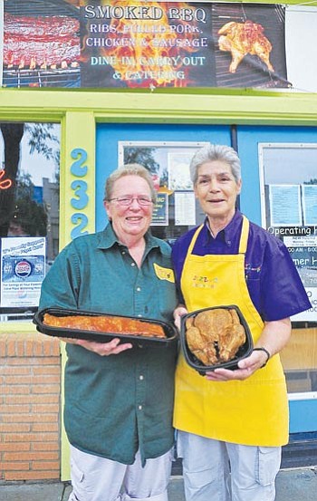 Matt Hinshaw/The Daily Courier<br>
Co-owners Toni Nipper, left, and Stephanie Stafford display a couple of their new items, a smoked barbecue rack of ribs and smoked barbecue chicken. 


