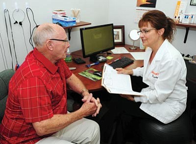 Les Stukenberg/The Daily Courier<br>
Zounds hearing aid specialist Dusty Spitler talks with Ron Busse during a follow up visit on his new hearing aid.