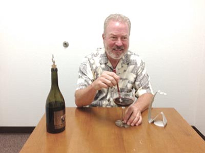 Ken Hedler/The Daily Courier<br>Jim Brister of Prescott demonstrates the use of the Ziblee by stirring a glass of pinot noir. He and his partner, Ian Percy of Scottsdale, are trying to promote the wand-like device to vintners, liquor stores and other potential users.