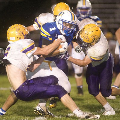 Les Stukenberg/The Daily Courier<br>A trio of defenders tries to tackle and strip the ball from Prescott’s Kaine Bayze in the first half against Blue Ridge Friday night in the Badgers’ season opener at home.
