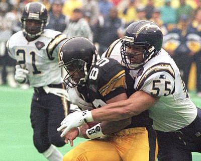 Keith Srakocic/The Associated Press<br>In this Jan. 15, 1995, file photo, Junior Seau, right, tackles the Steelers' Ernie Mills during the first quarter of the AFC Championship in Pittsburgh. Senior U.S. District Judge Anita Brody in Philadelphia, announced Aug. 29 that the NFL and more than 4,500 former players wanted to settle concussion-related lawsuits for $765 million. The plaintiffs included at least 10 members of the Pro Football Hall of Fame, along with and the family of Seau, who committed suicide last year. The global settlement will fund medical exams, concussion-related compensation and medical research.