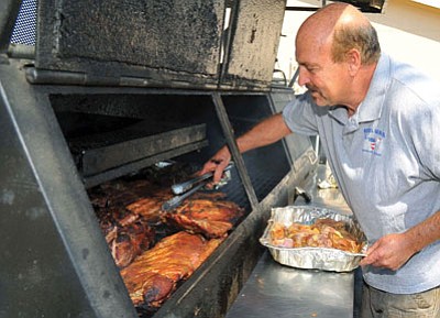 Matt Hinshaw/The Daily Courier, file<br>
Mike Jeffrey owner of Montana Barb-BQ Company turns a few of his meats at a recent event. Montana Barb-B-Q will serve as a “plate vendor” at this weekend’s cookoff at Tim’s Toyota Center in Prescott Valley.