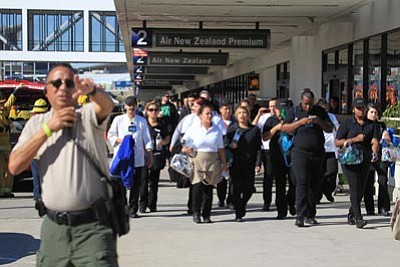 Passengers are directed outside Terminal 2 at Los Angeles International Airport on Friday Nov. 1, 2013, after shots were fired, prompting authorities to evacuate a terminal and stop flights headed for the city from taking off from other airports. (AP Photo/Ringo H.W. Chiu)