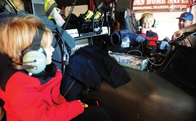 Les Stukenberg/The Daily Courier<br>
Lochlan and Loren Sweet get a personal tour of Central Yavapai Fire District’s Engine 50 from engineer Jeremiah King during a lunch visit.Their grandmother Susan Sweet won the luncheon in an auction benefiting the Coalition for Compassion and Justice.